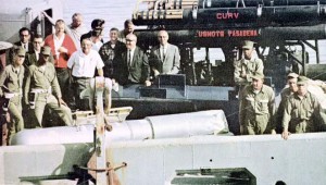 Navy personnel standing with a recovered hydrogen bom and ROV CURV I