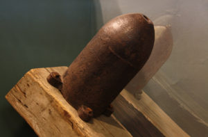 A Civil War era frame mine, which looks like a large artillery shell, is mounted on an angled wooden timber