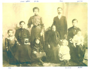 A family photograph from 1909 of five adults and four children
