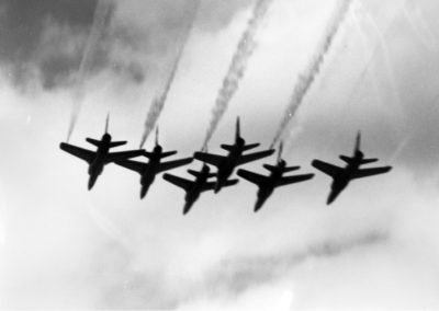 Six Blue Angels aircraft fly in formation through the air.