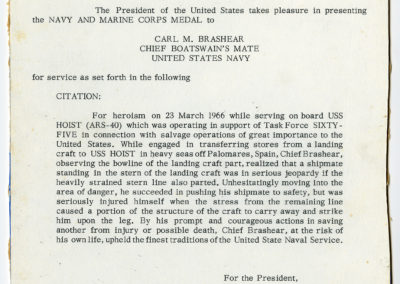 A typed citation from the Secretary of the Navy awarding Carl Brashear the Navy and Marine Corps Medal.