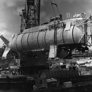 Large white submersible craned in the air
